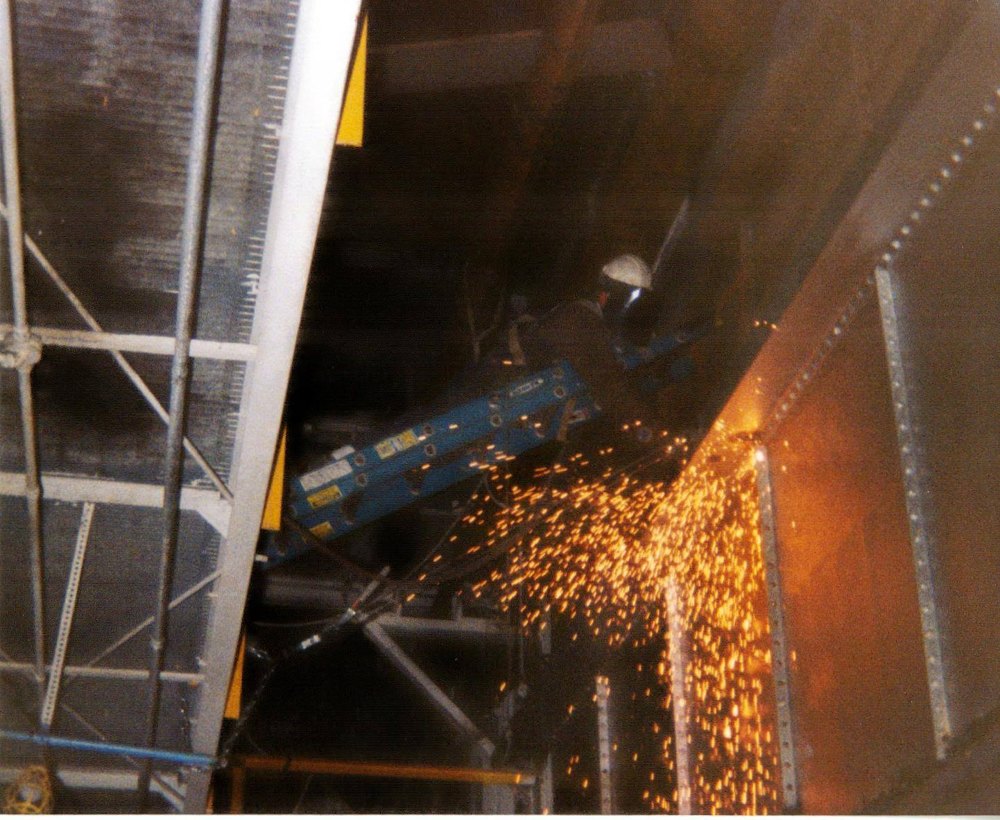 Up on an extended ladder with the welder, sparks flying